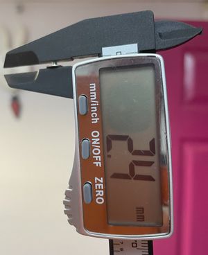 Image of laptop screw being measured with digital calipers.