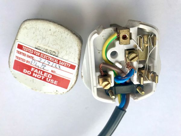 A mains plug with multiple faults.